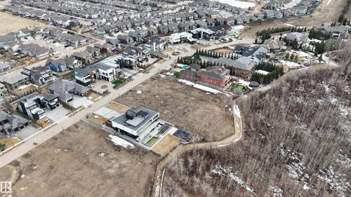 This property features a contemporary-style residence with a flat roof and a paved driveway - 24 Windermere Drive, Edmonton, AB 