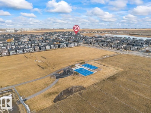 The property is situated within a community featuring residential houses and access to recreational courts - 42 Corner Glen Manor Ne, Calgary, AB - Outdoor With View