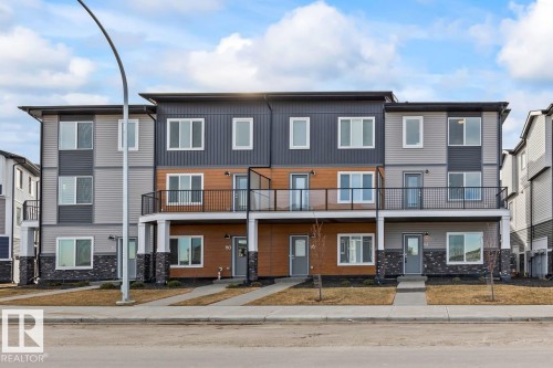 Contemporary multi-level property featuring a modern facade with varying siding textures and colors, prominent windows, and balconies with dark railings - 42 Corner Glen Manor Ne, Calgary, AB - Outdoor With Balcony With Facade