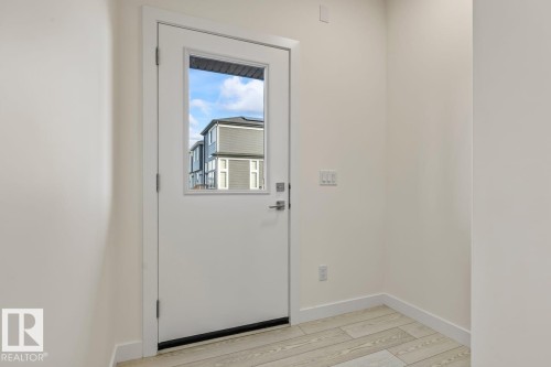Entryway featuring light-colored walls and a white door with a window - 42 Corner Glen Manor Ne, Calgary, AB - Indoor Photo Showing Other Room