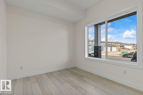 This room features light-toned flooring and white walls, creating a bright and airy atmosphere - 42 Corner Glen Manor Ne, Calgary, AB - Indoor Photo Showing Other Room