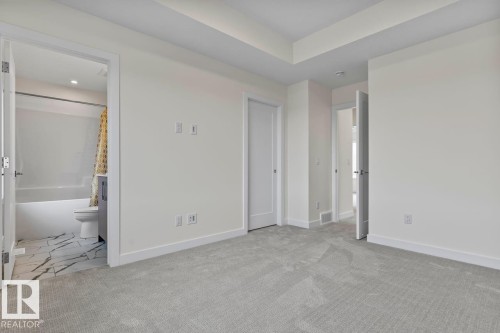 This room features light grey carpet flooring and white walls - 42 Corner Glen Manor Ne, Calgary, AB - Indoor Photo Showing Other Room