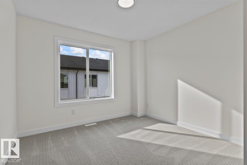 This room features light-colored carpeting, white walls, and a window providing natural light - 42 Corner Glen Manor Ne, Calgary, AB - Indoor Photo Showing Other Room