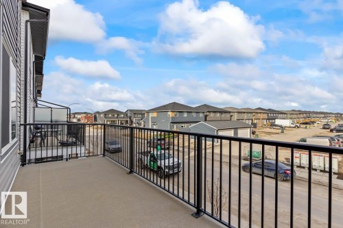 The property features a balcony with a concrete floor and black metal railings - 42 Corner Glen Manor Ne, Calgary, AB - Outdoor With Balcony