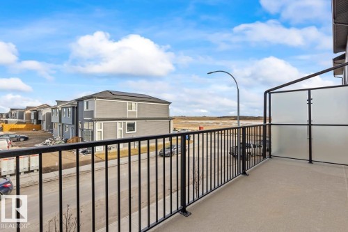 The property features a private balcony with a concrete floor, black metal railings, and frosted glass privacy panels - 42 Corner Glen Manor Ne, Calgary, AB - Outdoor With Balcony With Exterior