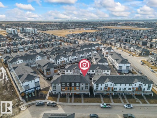 Aerial view showcasing a residential community with a variety of modern townhomes and detached properties - 42 Corner Glen Manor Ne, Calgary, AB - Outdoor With View