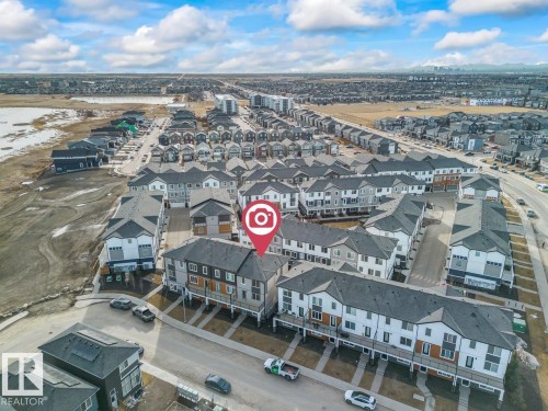 Aerial view of the property and its surrounding urban neighborhood, featuring a large body of water in the background - 42 Corner Glen Manor Ne, Calgary, AB - Outdoor With View