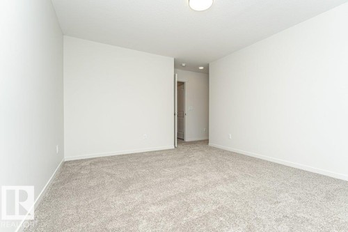 Spacious room with light-colored carpeting, white walls, and a ceiling light fixture - 6298 180 Avenue, Edmonton, AB - Indoor Photo Showing Other Room
