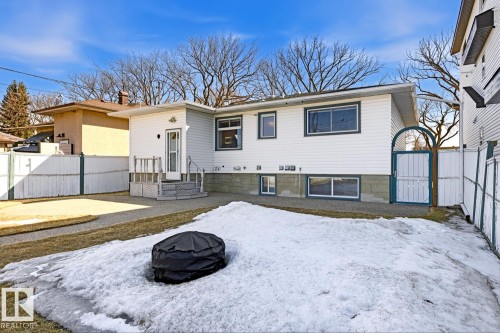 The property features a white exterior with white trim windows and a white fence - 10612 79 Street, Edmonton, AB - Outdoor