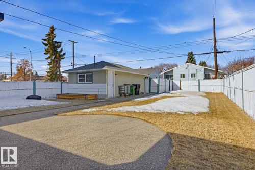 The property features a detached garage and a fenced yard with a paved driveway - 10612 79 Street, Edmonton, AB - Outdoor