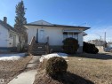 The property features a white exterior with a dark roof, a front porch with wooden steps, and a concrete pathway leading to the entrance - 10849 73 Avenue, Edmonton, AB  - Outdoor 