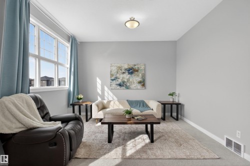 This inviting living area features light gray walls, a window with white framing, and light blue curtains - 42 Prescott Boulevard, Spruce Grove, AB - Indoor Photo Showing Living Room