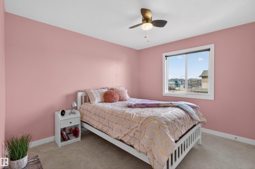 Bedroom featuring light pink walls, a window with a view of the surrounding neighborhood, and a ceiling fan with integrated lighting - 42 Prescott Boulevard, Spruce Grove, AB - Indoor Photo Showing Bedroom