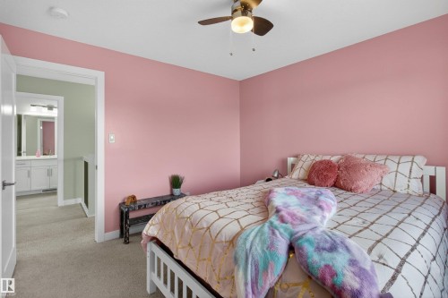 Bedroom featuring pink walls, a ceiling fan with integrated lighting, and carpeted flooring - 42 Prescott Boulevard, Spruce Grove, AB - Indoor Photo Showing Bedroom