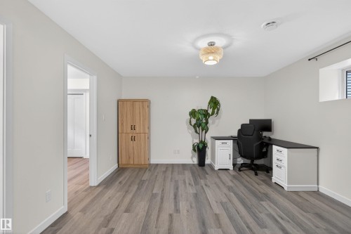 This versatile space features light-colored walls and gray wood-look flooring, complemented by a recessed window - 42 Prescott Boulevard, Spruce Grove, AB - Indoor