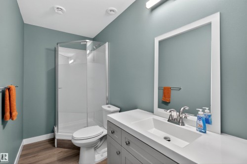 Bathroom featuring a shower stall with a glass enclosure, a toilet, and a vanity with an integrated sink and a framed mirror - 42 Prescott Boulevard, Spruce Grove, AB - Indoor Photo Showing Bathroom