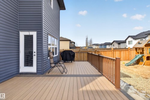 The property features a spacious deck with light-colored decking and a brown railing, accessible via a glass-paneled exterior door - 42 Prescott Boulevard, Spruce Grove, AB - Outdoor With Deck Patio Veranda With Exterior