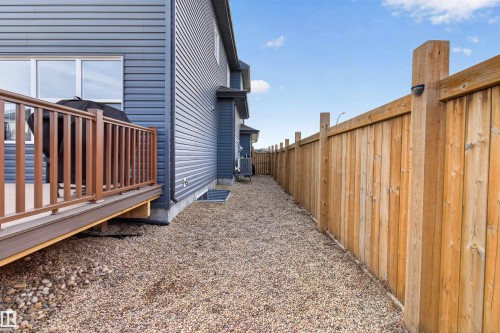 The property features a private fenced yard with a gravel pathway and a wooden deck with railing - 42 Prescott Boulevard, Spruce Grove, AB - Outdoor With Exterior