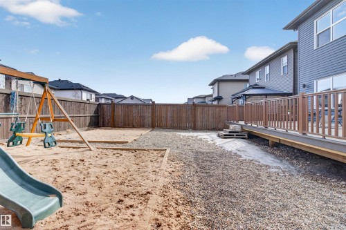 The property features a spacious backyard with a sandpit area and a swing set - 42 Prescott Boulevard, Spruce Grove, AB - Outdoor
