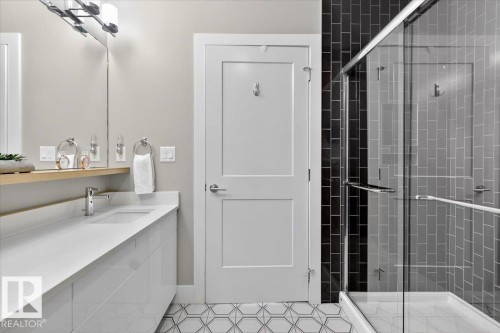 This bathroom features a contemporary vanity with an integrated sink and a large mirror - 214 528 Griesbach Parade Parade, Edmonton, AB - Indoor Photo Showing Bathroom