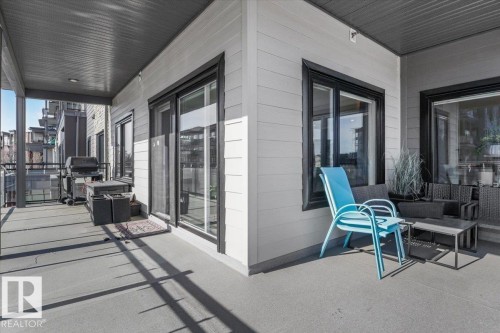 Expansive outdoor balcony with ample space, featuring durable concrete flooring and a partial overhang for shade - 214 528 Griesbach Parade Parade, Edmonton, AB - Outdoor With Deck Patio Veranda With Exterior