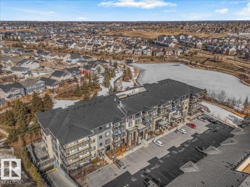 The property is an apartment building with several balconies, situated near a body of water and surrounded by residential housing - 214 528 Griesbach Parade Parade, Edmonton, AB - Outdoor With View