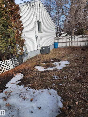 The property features white vinyl siding and a fenced yard - 10305 98 Avenue, Fort Saskatchewan, AB - Outdoor