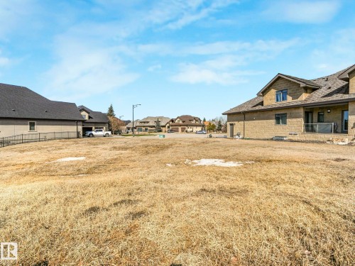 The property features a spacious yard with an expansive area of dry grass, offering ample space for various outdoor pursuits - 2794 Wheaton Drive, Edmonton, AB 