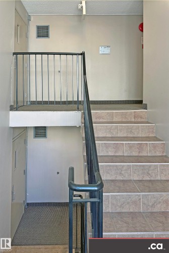 Stairwell featuring tiled stairs and metal railings - 303 8215 83 Avenue, Edmonton, AB - Indoor Photo Showing Other Room