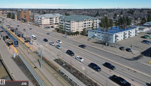 The property features a multi-story building with balconies, surrounded by paved parking areas - 303 8215 83 Avenue, Edmonton, AB - Outdoor With View