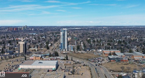 This aerial view showcases the property's advantageous location within a developed urban area, surrounded by a variety of buildings and infrastructure - 303 8215 83 Avenue, Edmonton, AB - Outdoor With View