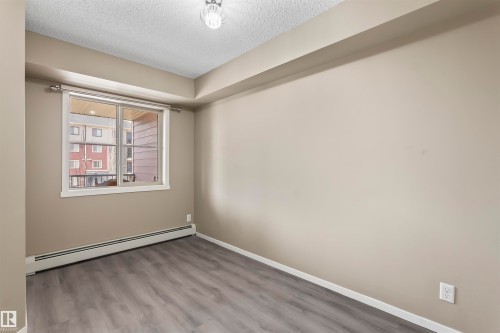 This room features light grey walls and grey wood-look flooring - 214 5816 Mullen Place, Edmonton, AB - Indoor Photo Showing Other Room