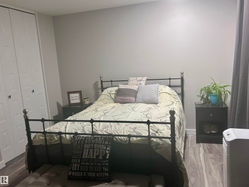 The bedroom features light grey walls and wood-look flooring - 4515 54 Ave, Tofield, AB - Indoor Photo Showing Bedroom