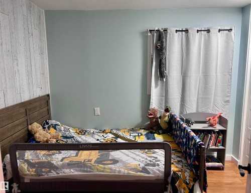 The room features light blue walls and a shiplap accent wall - 4515 54 Ave, Tofield, AB - Indoor Photo Showing Bedroom