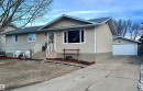 The property features a concrete driveway leading to a detached garage with a white sectional door - 4515 54 Ave, Tofield, AB  - Outdoor 