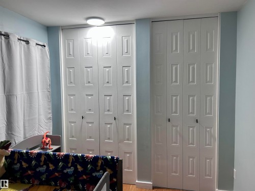 This room features two sets of white bi-fold closet doors, each with a paneled design - 4515 54 Ave, Tofield, AB - Indoor