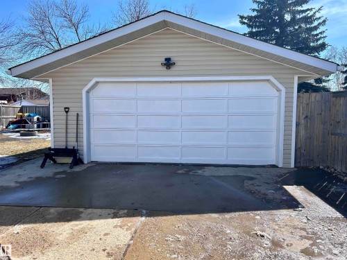 The property features a garage with light-colored siding and a white garage door - 4515 54 Ave, Tofield, AB - Outdoor With Exterior