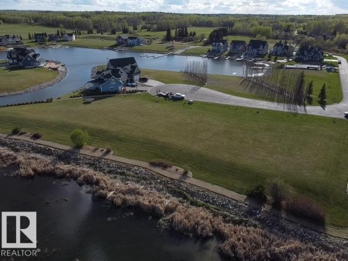 The property features expansive green lawns and a paved road - #1 Sunset Harbour, Rural Wetaskiwin County, AB 