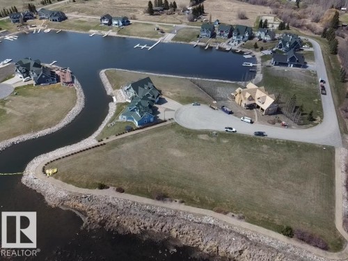 Waterfront property featuring a private boat dock, direct lake access, and a manicured lawn - #1 Sunset Harbour, Rural Wetaskiwin County, AB 