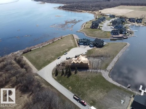 Waterfront property featuring a partially constructed residence, private dock, and surrounding green space - #1 Sunset Harbour, Rural Wetaskiwin County, AB 