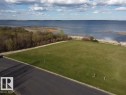 The property features a large grassy area with direct frontage to a body of water, offering expansive water views - #1 Sunset Harbour, Rural Wetaskiwin County, AB 