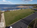 Expansive green lawn with water views, offering scenic vistas of the lake and surrounding natural landscape - #1 Sunset Harbour, Rural Wetaskiwin County, AB 