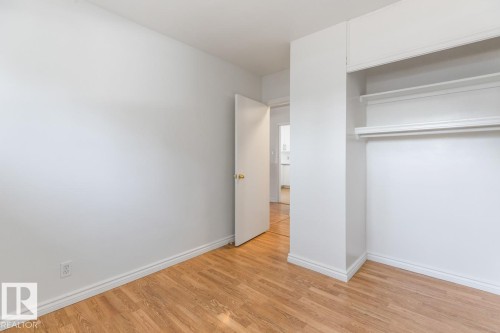 Room featuring light hardwood floors, white baseboards, and an open closet with shelves and a hanging rod - 13108 133 Street, Edmonton, AB - Indoor Photo Showing Other Room