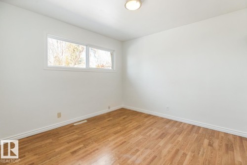 This room features light wood-style flooring, white walls, and a window providing natural light - 13108 133 Street, Edmonton, AB - Indoor Photo Showing Other Room