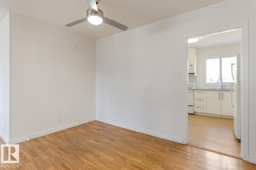 This bright space features hardwood flooring and a ceiling fan with integrated lighting - 13108 133 Street, Edmonton, AB - Indoor Photo Showing Other Room