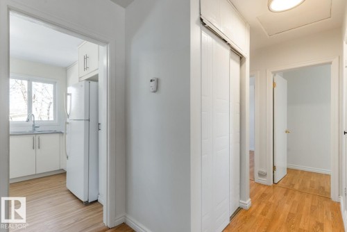 This interior view highlights a kitchen featuring a white refrigerator, white cabinetry, a sink with a faucet, and a window - 13108 133 Street, Edmonton, AB - Indoor Photo Showing Other Room