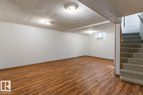This spacious area features wood plank flooring and white walls, with recessed lighting visible in the ceiling - 13108 133 Street, Edmonton, AB - Indoor Photo Showing Other Room