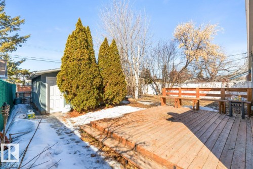 The property features a wooden deck with a built-in bench, offering a dedicated outdoor space - 13108 133 Street, Edmonton, AB - Outdoor With Deck Patio Veranda
