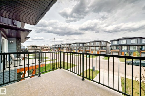 A private balcony with black metal railings provides views of the street and surrounding properties - 7822 Koruluk Link Link, Edmonton, AB - Outdoor With Balcony With Exterior