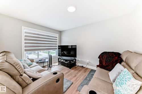 Living area featuring light-colored walls, recessed ceiling lighting, and wood flooring - 7822 Koruluk Link Link, Edmonton, AB - Indoor Photo Showing Living Room